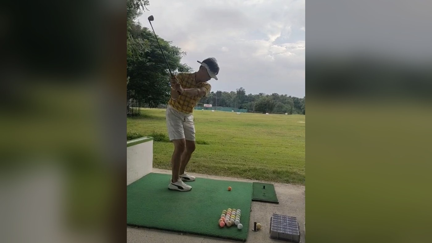 A golfer mid-swing at a driving range near Chiang Mai, part of the city's active outdoor and golf lifestyle